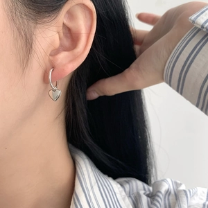 Boucles d'oreilles créoles coeur en argent massif S925 portées par un mannequin chic