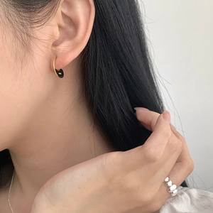 Detail of S925 sterling silver curved gold earring showing the hallmark on elegant model