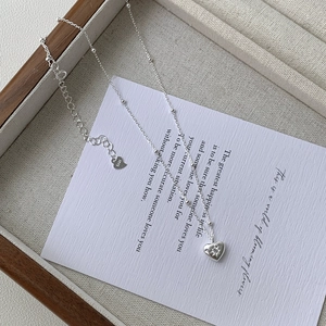 Collier cœur en argent S925 avec zircon étoilé sur présentoir à bijoux gris chiné