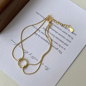 Macro detail of S925 sterling silver stamp on golden double-layer snake chain bracelet