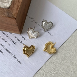 Brushed metal heart stud earrings in gold and silver finish with geometric texture