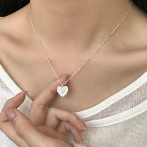 Detail of S925 sterling silver heart necklace featuring a textured sandblasted finish