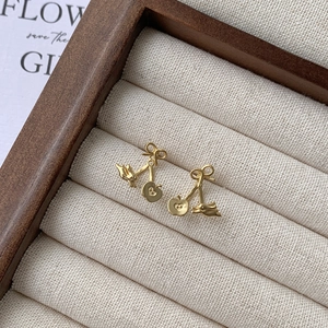 S925 silver golden bow earrings with cute rabbit and apple charms on a display tray