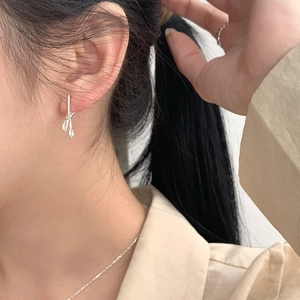Close-up of S925 sterling silver scissor-shaped hoop earrings on model ear