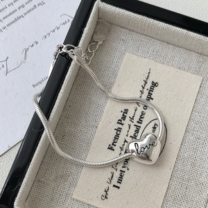 Macro shot of S925 sterling silver heart pendant with love engraving on snake chain