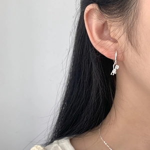 Close-up of minimalist S925 sterling silver hoop earrings with a small bear pendant