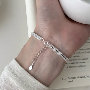 Minimalist S925 sterling silver double row cubic zirconia bracelet on a warm book background
