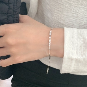 Close-up of double-layered silver chain bracelet with sliding beads on a model's wrist