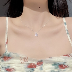 Close-up of S925 silver necklace with pink zircon star pendant worn by a model