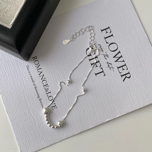 Macro detail of S925 sterling silver chain bracelet with polished heart charms and beads