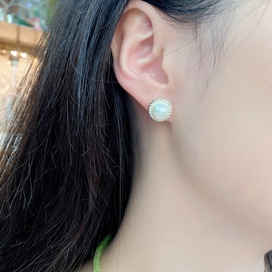 Elegant S925 sterling silver twist edge pearl stud earrings worn by a model