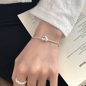 Minimalist S925 sterling silver heart snake chain bracelet worn with a wavy ring