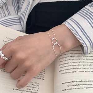 Detail shot of a minimalist S925 sterling silver geometric bracelet on an open book