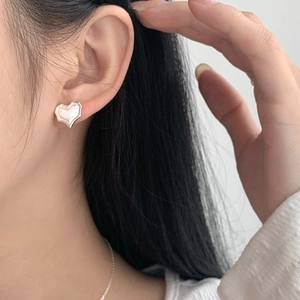 Minimalist S925 sterling silver heart stud earrings with brushed texture on female model