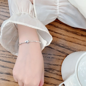 Elegant 925 sterling silver beaded bracelet featuring a polished heart charm on wrist