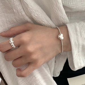 Close-up of a S925 sterling silver heart pendant and snake chain on a woman's wrist