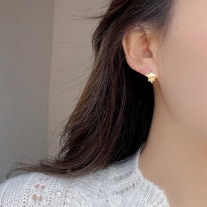 Elegant matte gold star stud earrings in S925 sterling silver worn by a model