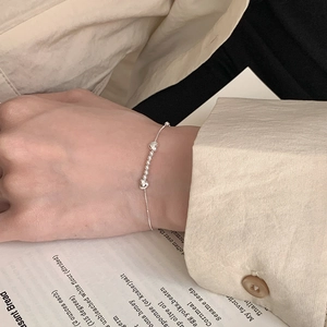 Minimalist S925 sterling silver beaded heart bracelet on wrist with elegant lifestyle backdrop