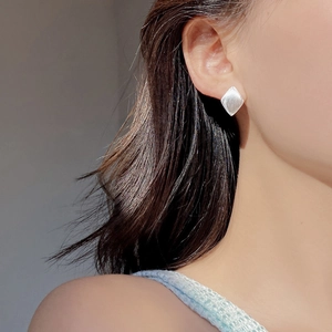 Close-up of S925 sterling silver geometric rhombus earring with brushed matte finish texture