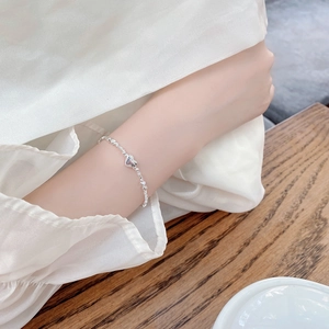 Handmade 925 sterling silver heart bracelet with irregular silver beads on a model's wrist