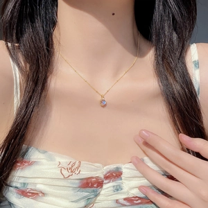 Close-up of a delicate gold S925 silver necklace with a glowing moonstone pendant