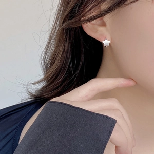 Minimalist S925 sterling silver star stud earrings with brushed matte finish on model