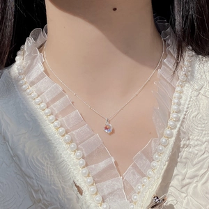 Close-up of S925 silver beaded chain with a moonstone pendant reflecting blue hues
