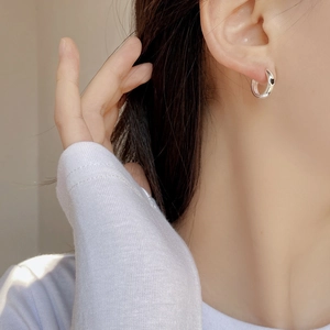 Orecchini a cerchio in argento sterling S925 con cuore nero indossati da una modella