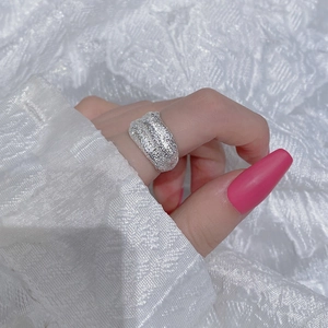 Macro detail of textured S925 sterling silver wide band ring with a sand texture finish