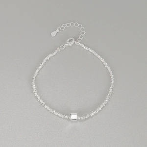 Minimalist S925 sterling silver bracelet with irregular cubic beads on a gray background