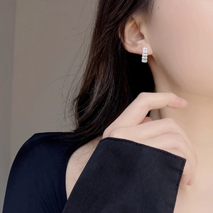 Close-up of baguette-cut zircon silver studs on ear, highlighting refined modern elegance