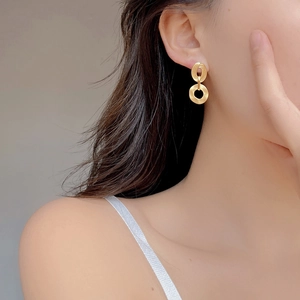 Minimalistische doppelte matte Goldohrringe aus S925 Silber am Ohr eines Models