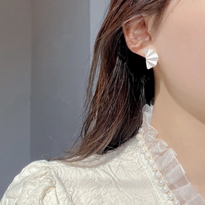 Minimalist S925 sterling silver fan-shaped stud earrings worn by model for elegant style