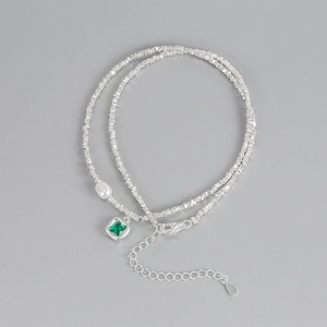 Macro view of S925 sterling silver chain with emerald zircon and elegant pearl detail