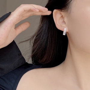 Close-up of 925 sterling silver earrings with rectangular cubic zirconia channel setting