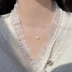 Close-up of elegant S925 silver necklace with white baroque pearl pendant on a model