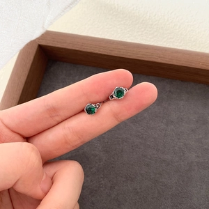 Detailaufnahme von 925er Silberohrsteckern mit smaragdgrünem Zirkonia im Vintage-Stil