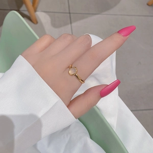 Detailed close-up of adjustable gold ring with oval cat eye stone on female hand