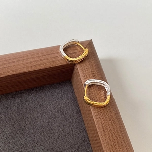 Detail of square S925 sterling silver earrings with hammered texture and two-tone finish