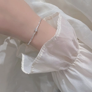 Macro view of minimalist S925 sterling silver bracelet with irregular cubic charm on wrist