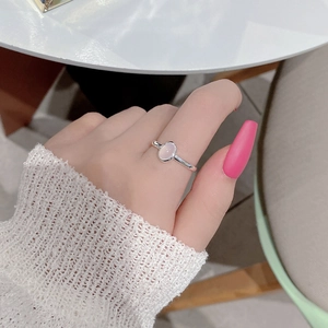 Close-up of S925 silver ring with oval pink cat eye stone on hand with lace sleeve