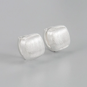Close-up of matte brushed silver square hoop earrings showing fine metal texture
