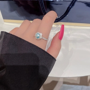 S925 sterling silver ring with lava texture and pearl, worn on a hand against white background