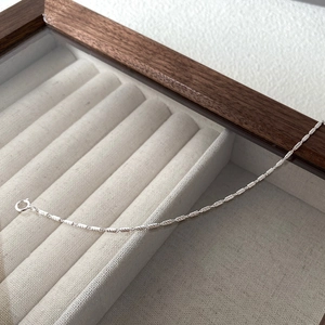 Detail of S925 sterling silver barrel-link bracelet with spring clasp on velvet display