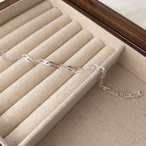Close-up of S925 silver link bracelet with four-leaf clover patterns and lobster clasp
