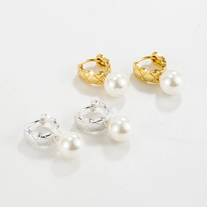 Macro detail of quilted pattern gold and silver earrings with round white pearls