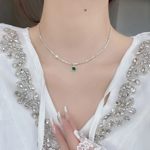Elegant S925 sterling silver emerald necklace with pearl accent on a female model