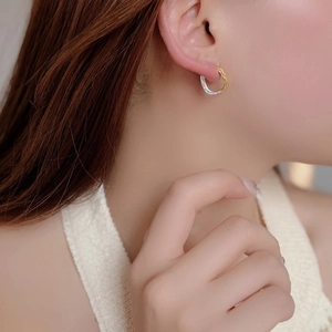 Close-up of S925 sterling silver square earrings with gold and silver wave texture