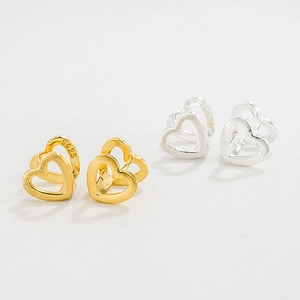 Macro detail of S925 sterling silver stamp on brushed gold heart-shaped earrings