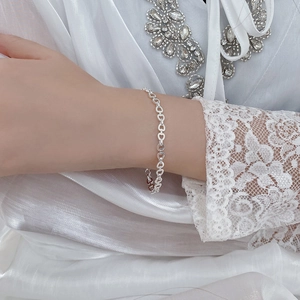 Detail of S925 sterling silver heart chain bracelet worn on a woman's wrist
